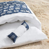 Gros plan sur une couette fermée avec oreiller pour chat, design bleu et blanc, idéale pour le confort et la relaxation.
