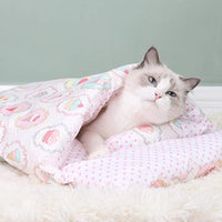 Chat blanc confortablement blotti dans une couette pour chat rose, design élégant et chaleureux avec oreiller assorti.