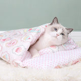 Chat blanc confortablement blotti dans une couette pour chat rose, design élégant et chaleureux avec oreiller assorti.