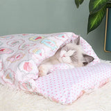 Chat blanc endormi dans une couette pour chat douce et rose, motif pastel avec cupcakes, parfait pour un sommeil paisible.
