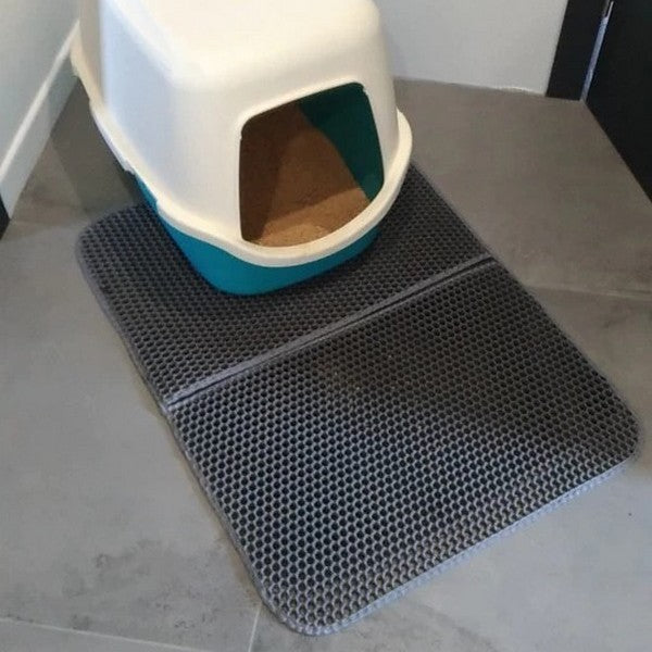 Présentation de notre tapis de litière pour chat gris devant un bac à litière fermé